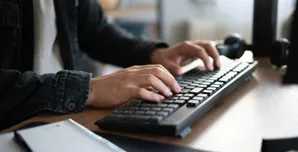 Specjalista IT pracujący przy komputerze i obsługujący systemy firmowe